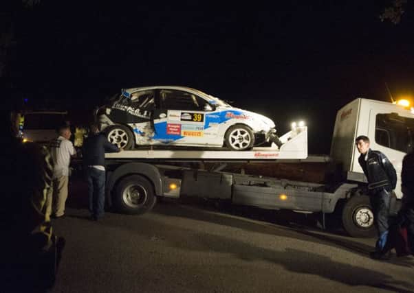 A damaged rally car sits on the back of a flatbed tow truck near the village of Carlal where six people lost their lives. Picture: AFP/Getty