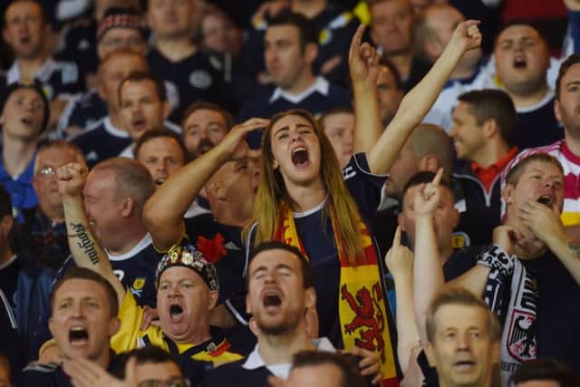 A Scotland fan sings her heart out in the stands. Picture: SNS