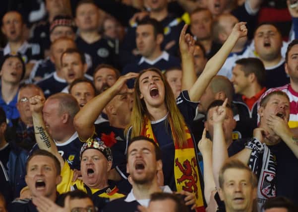 A Scotland fan sings her heart out in the stands. Picture: SNS
