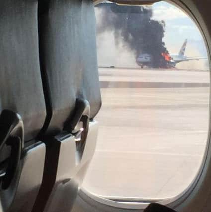 Smoke billows out of the BA flight as seen from a nearby aircraft. Picture: David Somers / AP