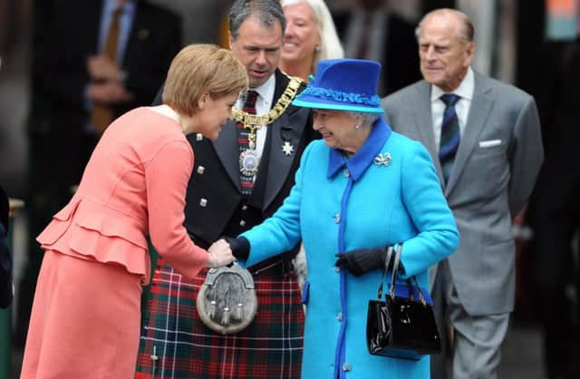 Girls' day out: First Minister and Queen in amicable greeting, perhaps to the puzzlement of the duke. Picture: Neil Hanna