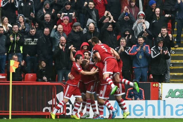The Aberdeen players celebrate their equalising goal in front of their fans. Picture: SNS