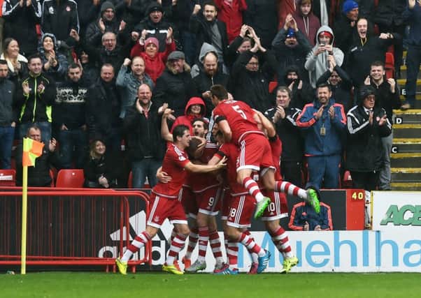 The Aberdeen players celebrate their equalising goal in front of their fans. Picture: SNS