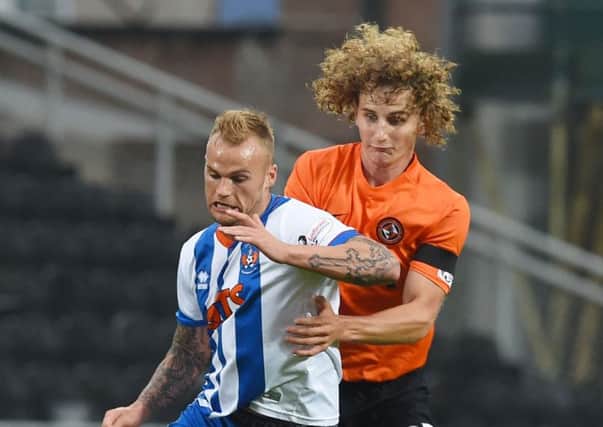 Kallum Higginbotham holds off the challenge of Aaron Kuhl at Tannadice. Picture: SNS