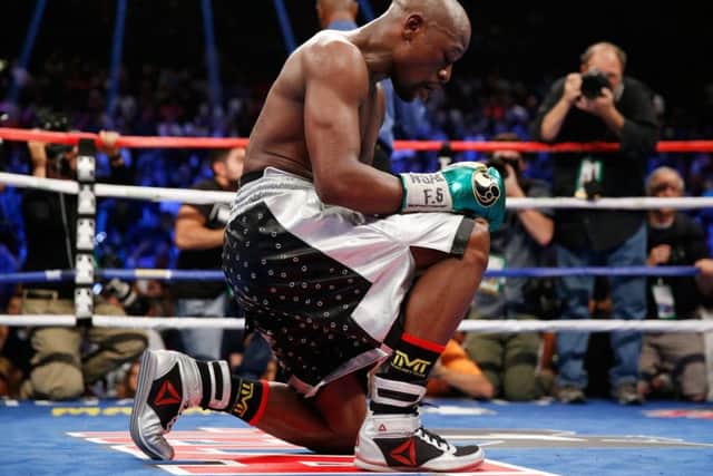 Floyd Mayweather kneels on the mat following his victory over Andre Berto. Picture: Getty