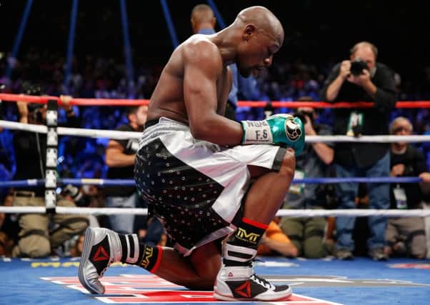 Floyd Mayweather kneels on the mat following his victory over Andre Berto. Picture: Getty