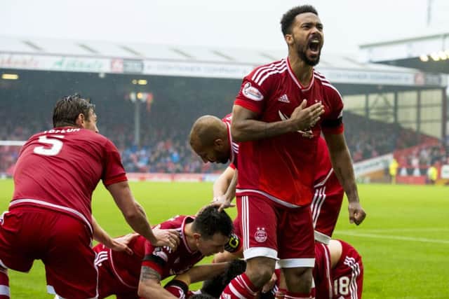 Aberdeen's Shay Logan celebrates after team-mate Paul Quinn (hidden) scores his side's winning goal. Picture: SNS