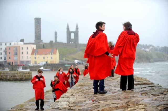 St Andrews students wearing the iconic red gowns seen on the town's pier. Picture: Jane Barlow