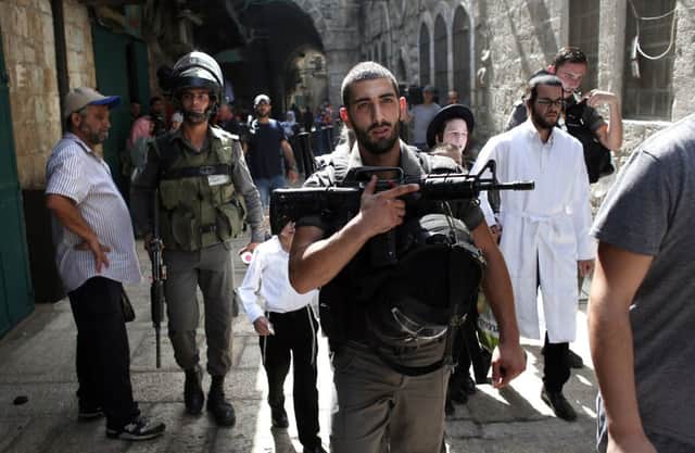 Israeli security forces escort Jewish worshippers from the Western Wall through Jerusalem's Muslim quarter yesterday. Picture: AFP/Getty