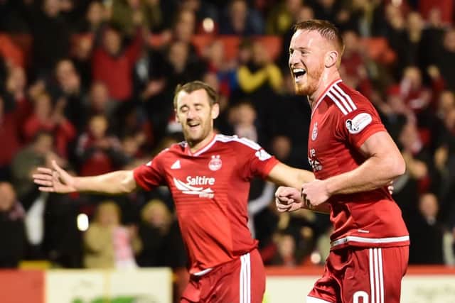 Aberdeen's Adam Rooney (right) celebrates having fired home from the penalty spot to put his side ahead. Picture: SNS