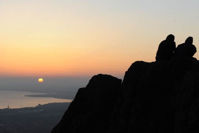 Students watch the sunrise from the summit of Arthurs Seat. 
Picture: Neil Hanna