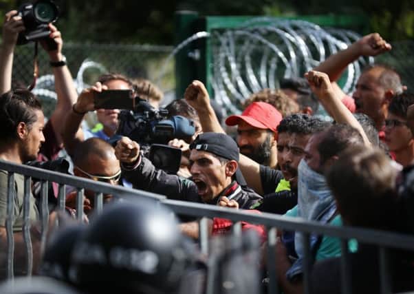 Angry migrants face the police at a border crossing in Horgos, Serbia. Picture: Getty