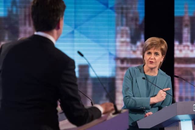 Nicola Sturgeon speaks to Ed Miliband during one of the debates. Picture: Getty