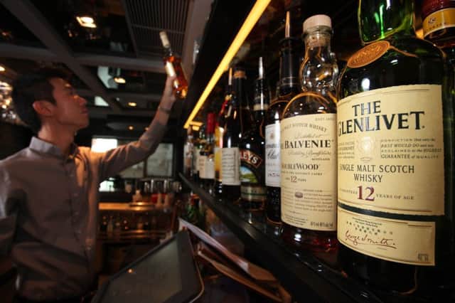 In a picture taken on September 17, 2011 a barman selects a bottle of whisky from a display at the 'Angel's Share' whisky bar in Hong Kong. Whisky shipments to Asia increased by 33 percent, according to new figures released by the Scotch Whisky Association (SWA). The SWA also said that global shipments between January and June had reached 1.8 billion British pounds (2.8 billion USD), up from 1.47 billion British pounds (2.3 billion USD) achieved during the same period in 2010. AFP PHOTO / ED JONES (Photo credit should read Ed Jones/AFP/Getty Images)