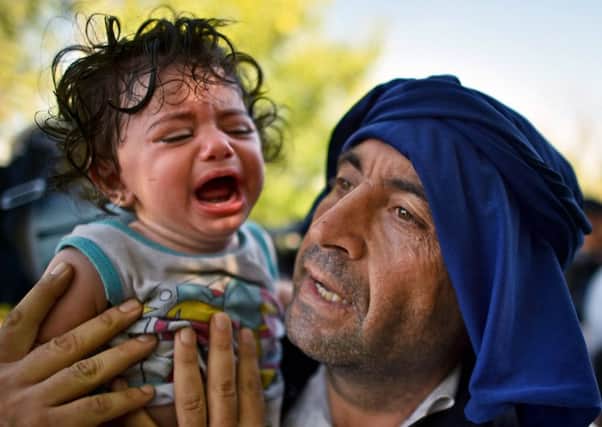 A child cries as migrants force their way through police lines in Croatia. Picture: Getty