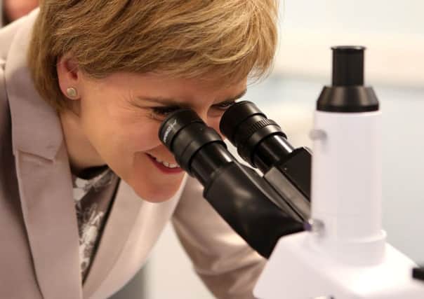 First Minister Nicola Sturgeon looks through a microscope at Clyde BioSciences. The Scottish Government is stepping up its drive to recruit Scotland's chief scientific adviser. Picture: PA