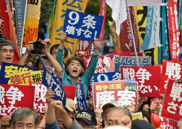 Opponents of the planned easing of Japans pacifist constitution mounted further street protests outside Parliament yesterday. Picture: Getty
