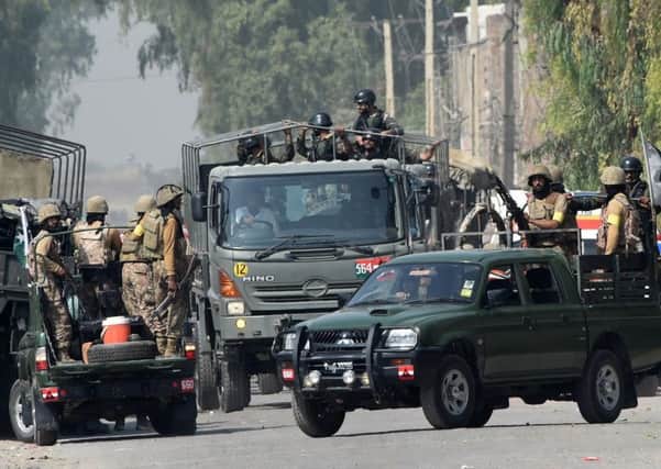 Pakistani troops and security officials outside the airforce base in Peshwar in which the Taleban killed 20 people. Picture: Getty
