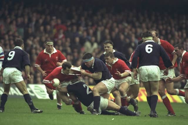 Rob Howley (centre left) is stopped by Peter Wright (centre) during the 1996 Five Nations Championship match between Wales and Scotland. Picture: David  Rogers/Allsport
