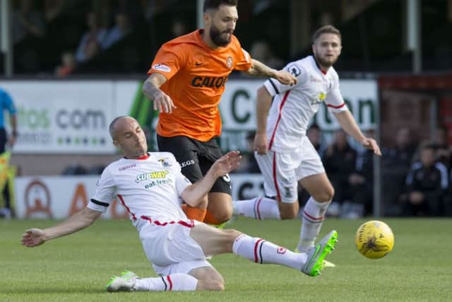 David Raven (left) challenges Dundee Utd's Darko Bodul. Picture: SNS Group