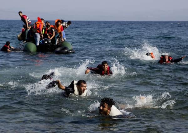 Desperate migrants whose boat stalled while crossing from Turkey to Greece are forced to swim to shore, on the island of Lesbos yesterday. Picture: AP