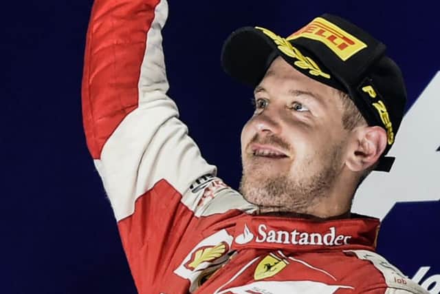 Sebastian Vettel stands aloft the podium to celebrate his victory. Picture: AFP/Getty