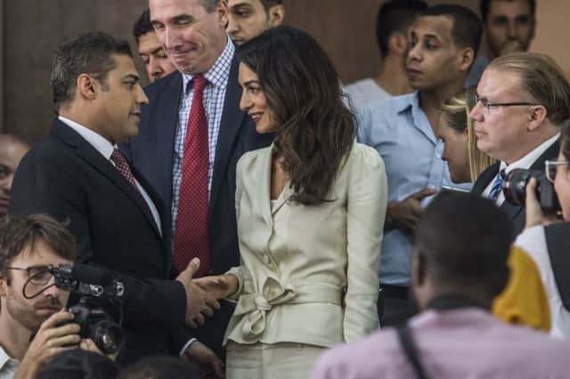 Canadian journalist Mohamed Fahmy shakes hands with Amal Clooney. Picture: Getty