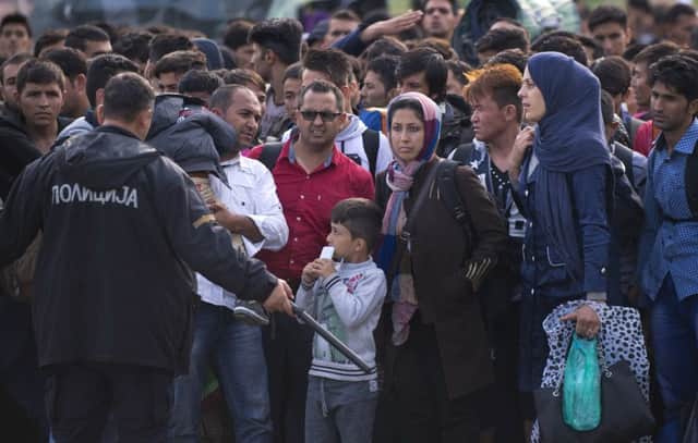Migrants and refugees preparing to enter a camp after crossing the Greek border from Macedonia. Picture: AFP/Getty