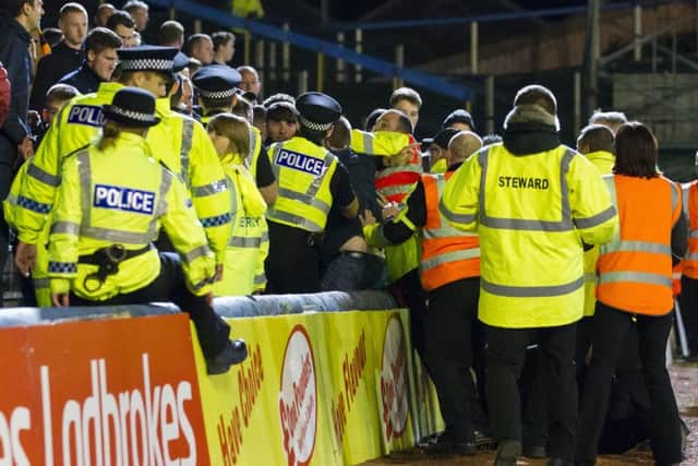 Police and stewards deal with the disturbance in the crowd during the League Cup encounter. Picture: SNS
