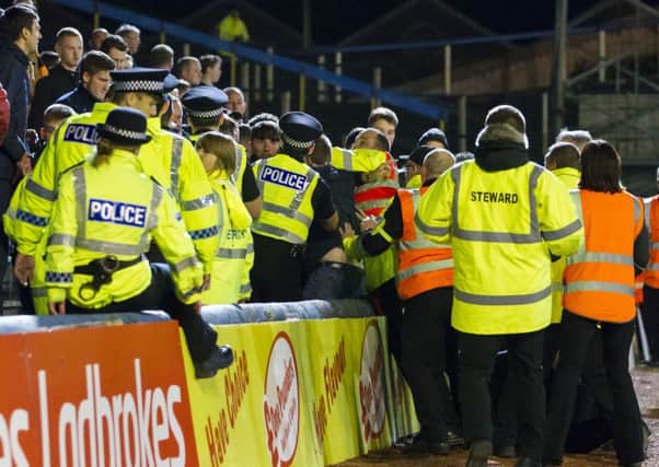 Police and stewards deal with the disturbance in the crowd during the League Cup encounter. Picture: SNS