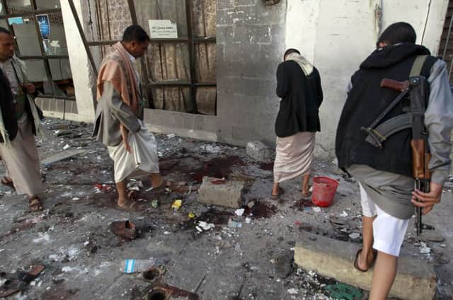 Yemeni Huthi rebels check the mosque in the capital Sanaa, following the explosion yesterday. Picture: AFP/Getty