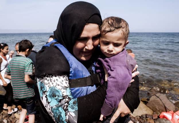 A woman hugs her child on Eftalou beach, Lesbos after crossing the Aegean sea. Picture: Getty