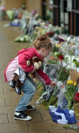 A girl lays a floral tribute at the scene in 2013. Picture: Phil Wilkinson