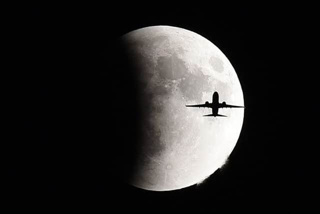A plane flies in front of the supermoon during the lunar eclipse over Geneva in Illinois. Picture: Jeff Knox/Daily Herald via AP