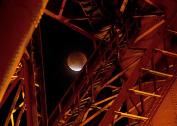 The Super Blood Moon seen through the red structure of the Forth Rail Bridge. Picture: Hemedia