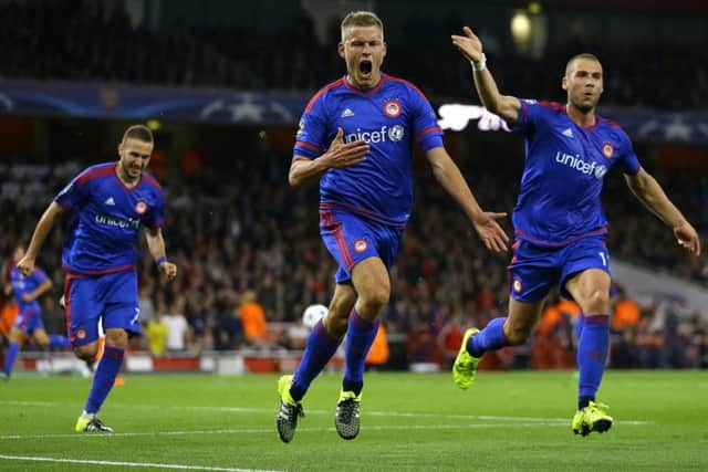 Olympiakos sub Alfred Finnbogason, left, celebrates his goal at the Emirates Stadium last night. Picture: AP