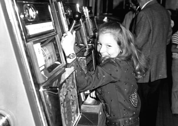 Scottish entertainer Lena Zavaroni playing the slot machines/one-armed bandits at Blackpool funfair when she was ten.