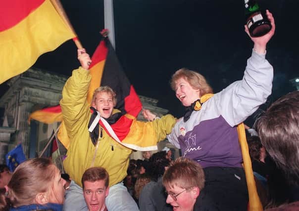 Jubilant young Berliners celebrating 25 years ago. Picture: Getty