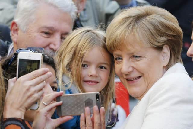 Chancellor Angela Merkel poses for a selfie during celebrations marking German reunification. Picture: AP