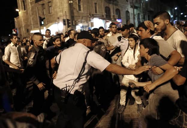 Far-right militant Israelis are held back by police as they protest in Jerusalem over the stabbings. Picture: Getty