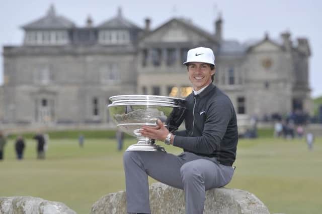Smiling at last with a trophy, Thorbjorn Olesen sits on the Swilken Bridge after his Dunhill victory. Picture: PA