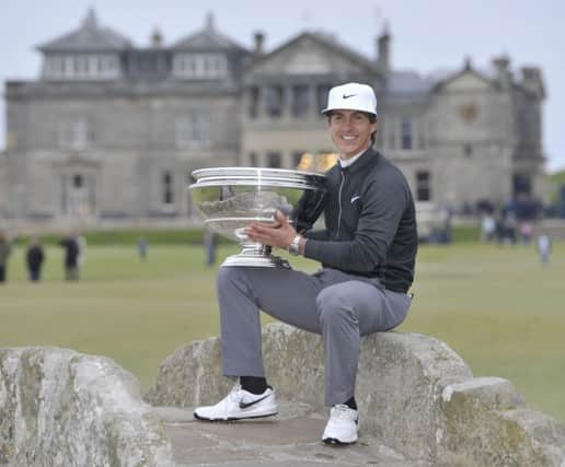 Smiling at last with a trophy, Thorbjorn Olesen sits on the Swilken Bridge after his Dunhill victory. Picture: PA