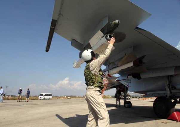 A Russian pilot checks a missile on his Su-30 warplane at a base in Syria on Monday, before a sortie. Picture: AP