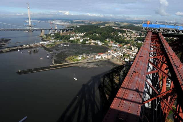 The Queensferry Crossing is seen in the distance from the Forth Bridge, opened in 1890, with the village of North Queensferry and the Forth Road Bridge in between. Picture: Lisa Ferguson