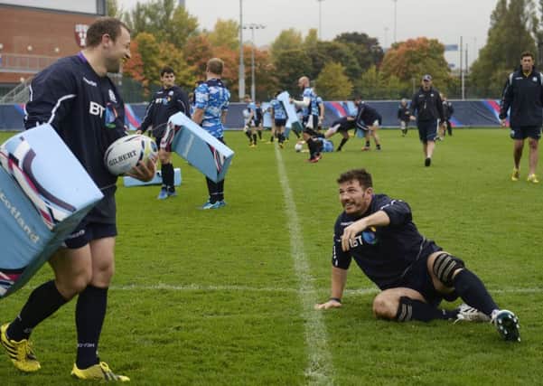 Tim Swinson, right, is grounded in training, much to the amusement of Scotland team-mate Ryan Grant. Picture: PA