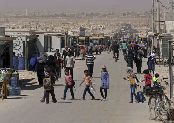 Syrian refugees stroll on the main street of Zaatari refugee camp near Mafraq, northern Jordan. Picture: AP
