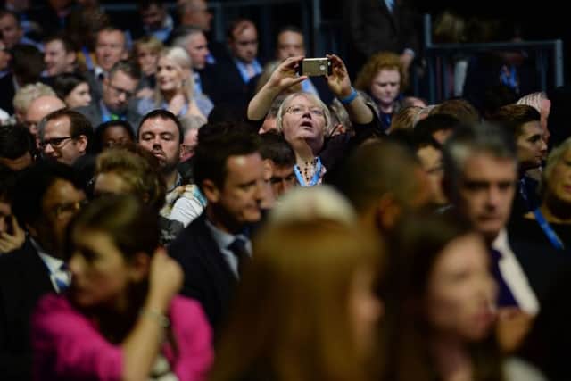 A delegate takes a photo before Prime Minister David Cameron . Picture: PA