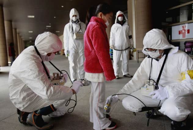 A youngster  is screened for radiation from the tsunami-damaged Fukushima Dai-ichi nuclear plant. Picture: AP