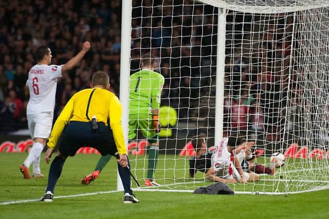 Robert Lewandowski slides in at the back post to score Polands equaliser with the last kick of the game. Picture: John Devlin