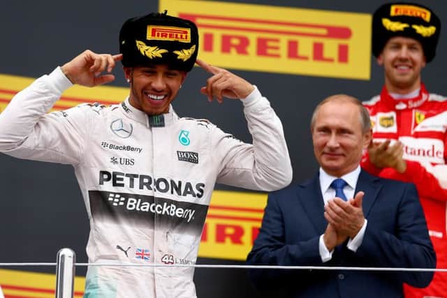 Lewis Hamilton, left, is all smiles on the podium next to Russian president Vladimir Putin, centre, and Germanys Sebastian Vettel, right. Picture: Getty Images